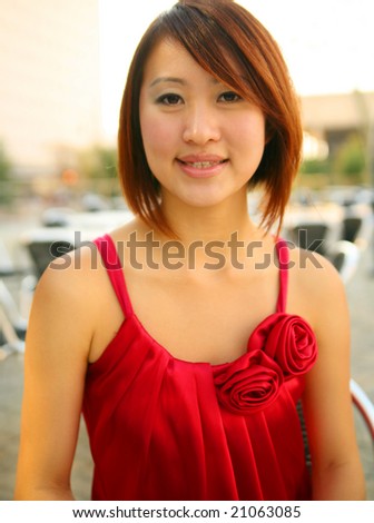 close up of pretty asian young asian girl in red dress sitting outdoor