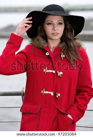 Pretty young female in red coat and hat