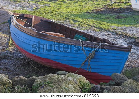 Blue & red wooden rowing boat on land