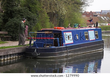 Man with blue narrow boat on canal