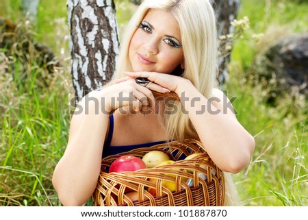 Spring time. Young woman with basket of apples