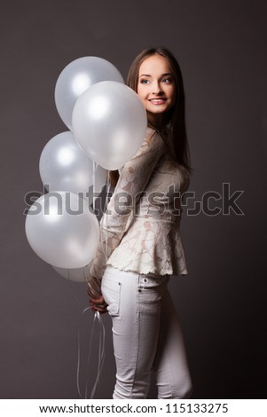 Beautiful fashion woman in studio with white balloons
