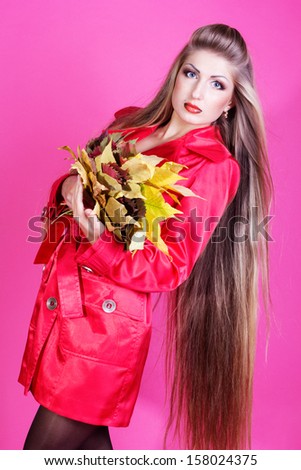 Autumn woman  with colorful fall leaves isolated on pink