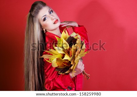 Autumn woman  with colorful fall leaves isolated on red