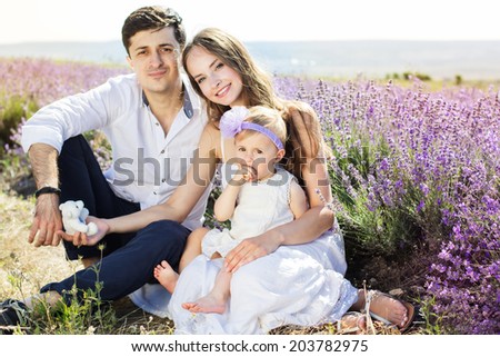 Happy family mother, father and daughter having fun in lavender field