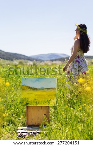 Young artist girl is create picture of an floral landscape, spring time