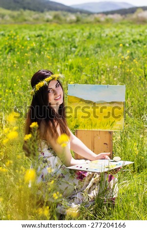 Young pretty artist girl is create picture of an floral landscape, spring time