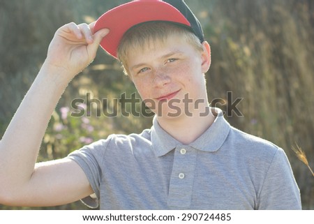 Portrait of cute boy with freckles is wearing cap, summer time