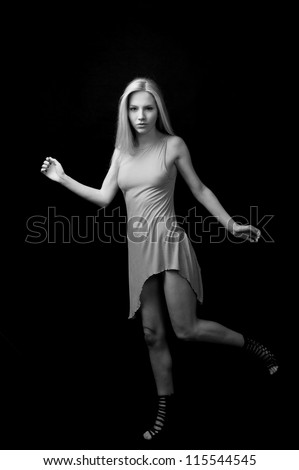 female fashion model posing at black background full length