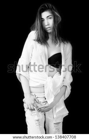 fashion model wearing black bra white shirt and white jeans against black background