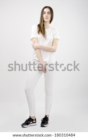 20 years old female fashion model wearing white clothes against white background high key