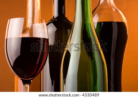bottles from white, red and sparkling wine and glass of red wine
