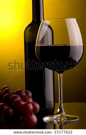 a glass of red wine and grape and bottle