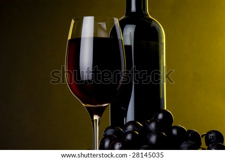 a glass of red wine bottle and grape