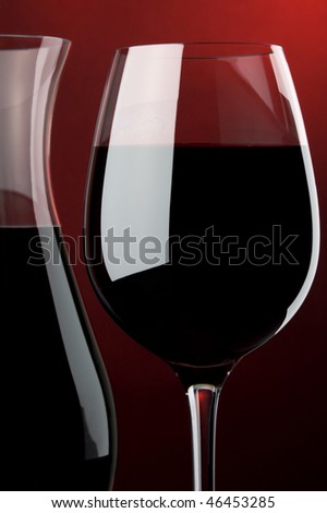 a glass and a jug with red wine details