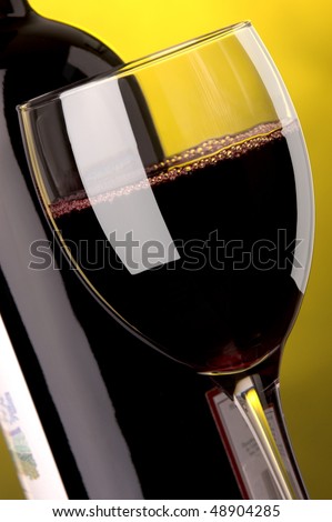 a glass and a bottle of red wine details