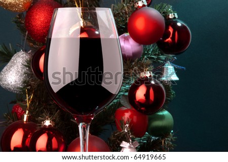 a glass of red wine detail and Christmas tree at background