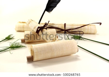 yellowed papyrus scrolls with quill, inkpot and papyrus on a light background