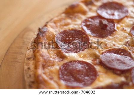 Close up of a pepperoni pizza on a cutting board on the family table with natural lighting