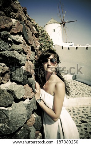 Young woman on holidays, Santorini Oia town. Photo in vintage style