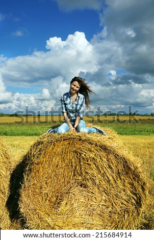 Autumnal nature; Yoing woman in haystacks on fields
