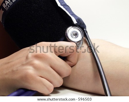 Blood pressure cuff around arm with stethoscope isolated on white