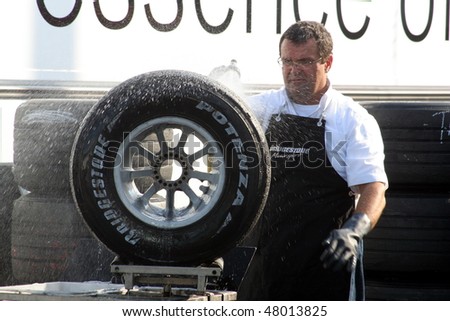 HOCKENHEIM, GERMANY - CIRCA 2010: A crew member washes down a Formula 1 wheel to prepare for the new season of Formula 1 racing on March 14, 2010.