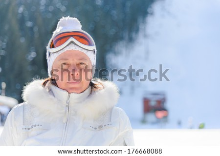 middle-aged woman in a white jacket and ski cap glasses