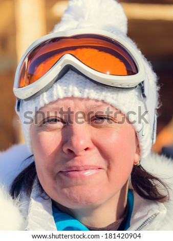 middle-aged woman in a white jacket and ski cap glasses