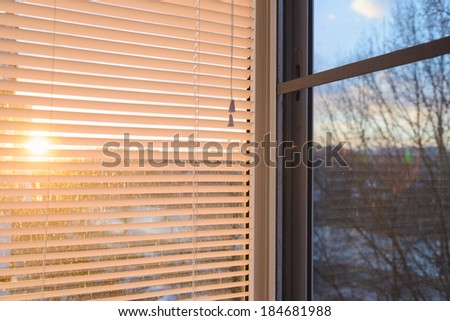 closed plastic blinds on the window with the reflection in the glass