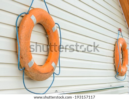 orange life buoy with rope hanging around the pool