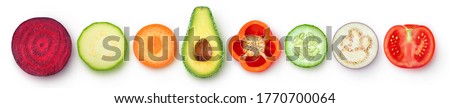 Isolated vegetable pieces. Raw vegetables slices of different color and shape (beetroot, zucchini, carrot, avocado, bell pepper, cucumber, eggplant, tomato), top view isolated on white background