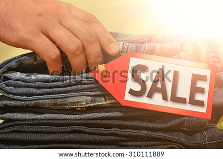 Seasonal sale. Man's hand touches pile of clothes, shopping, black friday, columbus day sale, labor day sale
