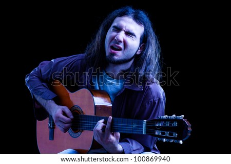 Man Playing Classical Guitar and Singing on Black Background