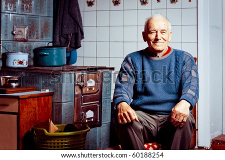 Old man sitting by his tile stove
