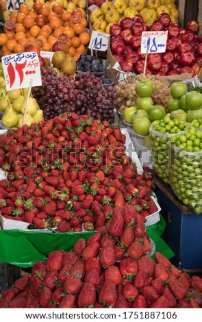 Organic Fruits in a Traditional Bazaar in Iran. Translation of Price Tags: Strawberries of Sanandaj City, 12000 Tomans per Half a Kilo - Grapes of Shahroud, 15000 Tomans - Black Plumes, 15000 Tomans Imagine de stoc © 