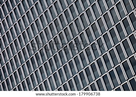 Abstract background of a modern glass skyscraper with dark windows.