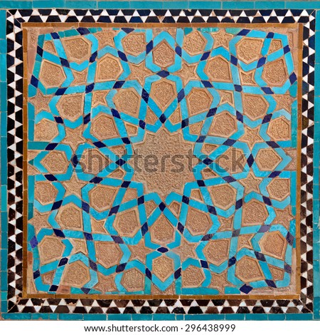 Traditional old Islamic design with flowers and stars made of brown clay and blue tiles in Yazd.