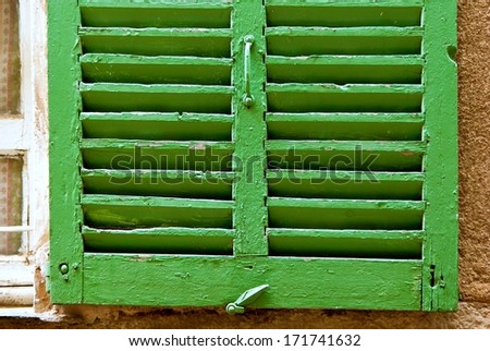 Closeup of a green jalousie window shutter in France.