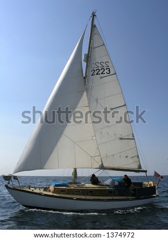 Yacht sailing with full sails: jib and mainsail in a sunny weather