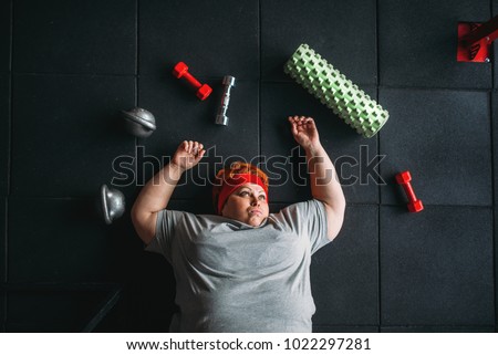 Tired fat woman lies on the floor in gym Foto stock © 