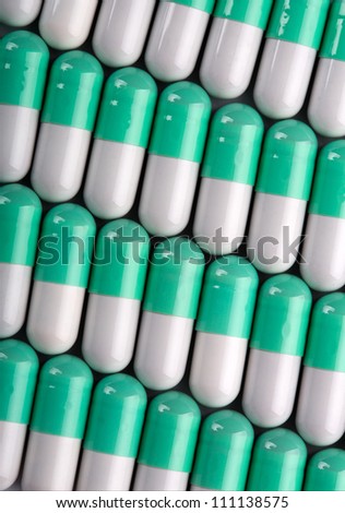 Background of green-white pills in a rows