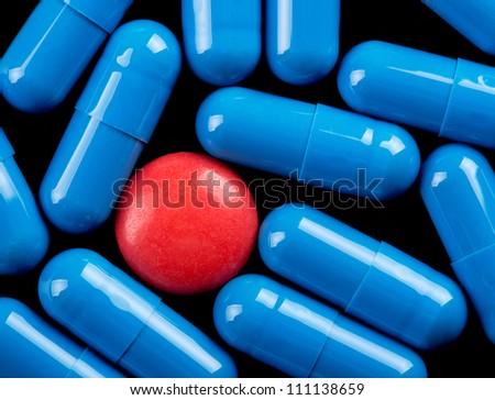 Special red pill between blue capsules