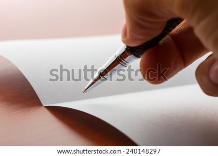 Human hand writing on paper by ball pen