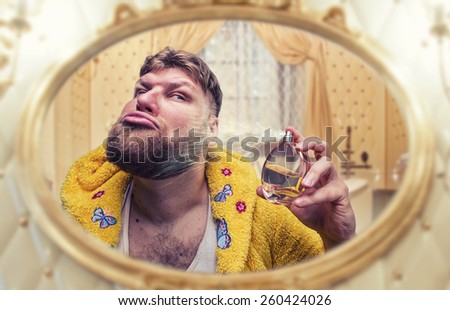 Strange man perfumes himself looking in the mirror