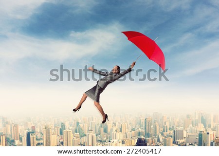 Scared woman flying in the sky with umbrella