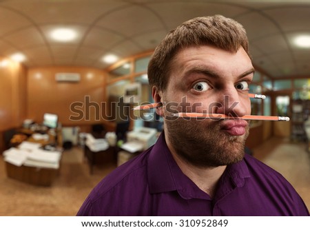 Strange man holds pencil with his nose and lips