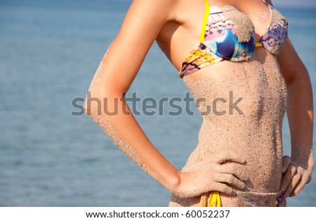Hot and wet. Close-up of sandy woman perfect body