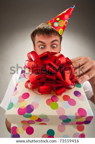 Surprised birthday man opening big gift box