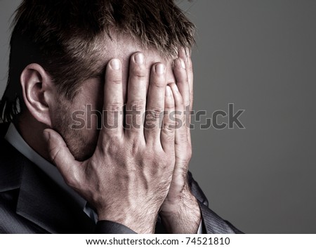 stock-photo-exhausted-sad-businessman-covering-his-face-by-hands-74521810.jpg